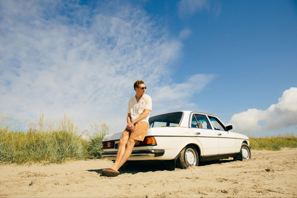 Man wearing Magnolia clothing leaning on a car