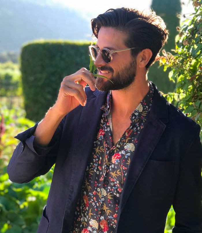 man at summer wedding wearing a floral shirt and blue blazer