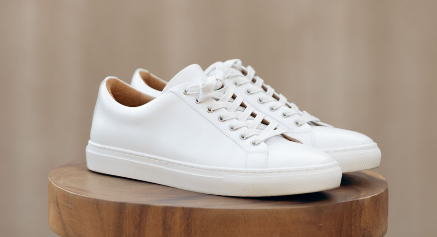 a pair of white leather lace up sneakers