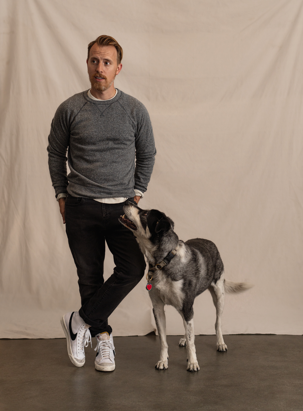 man wearing grey crewneck sweatshirt with black jeans and hi top sneakers