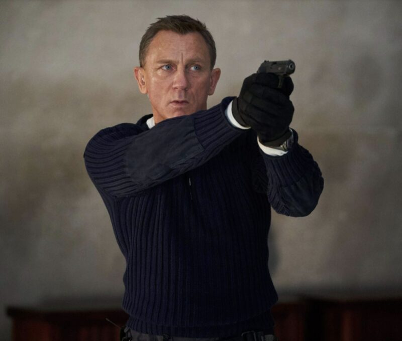 daniel craig james bond wearing a navy sweater and black gloves