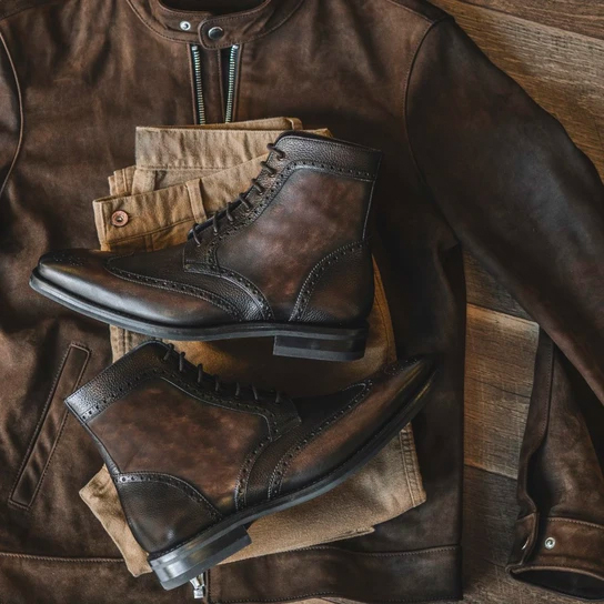 brown wingtip boots on a pair of chinos and leather jacket