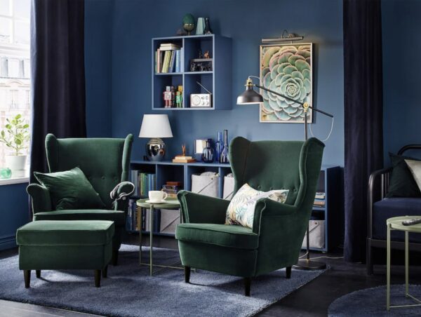 image of a living room setting with green armchairs and a floor lamp