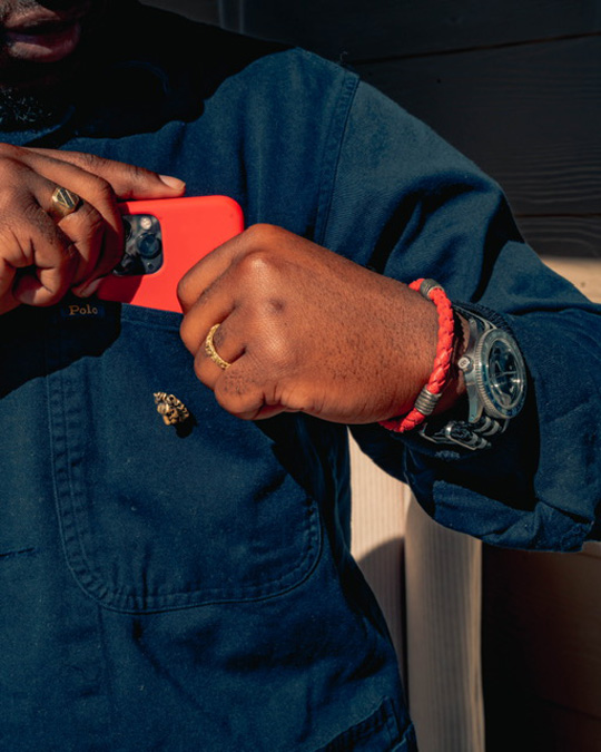 a close up of outfit accessories including a wrist watch, bracelet, and a mobile phone device