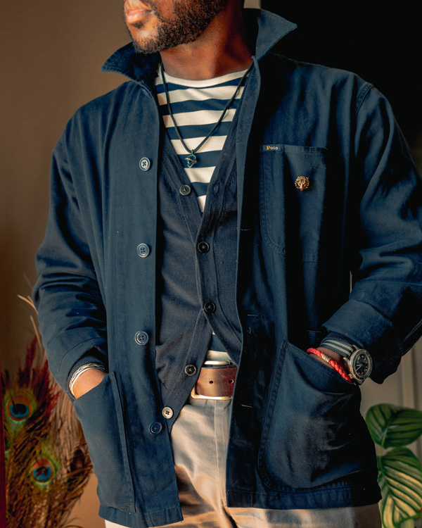 a casual outfit made with a navy chore coat over top of a cardigan and striped t-shirt