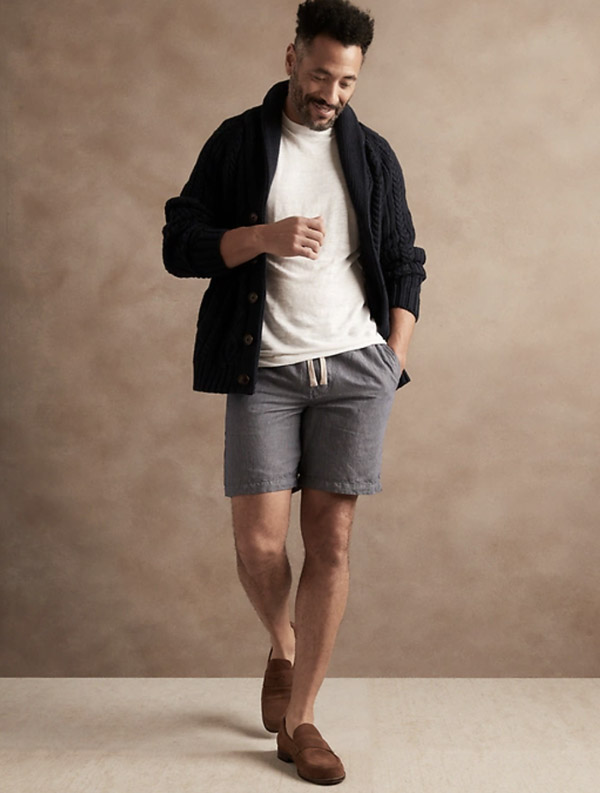 image of a man wearing navy and white stripe shorts and a black overshirt