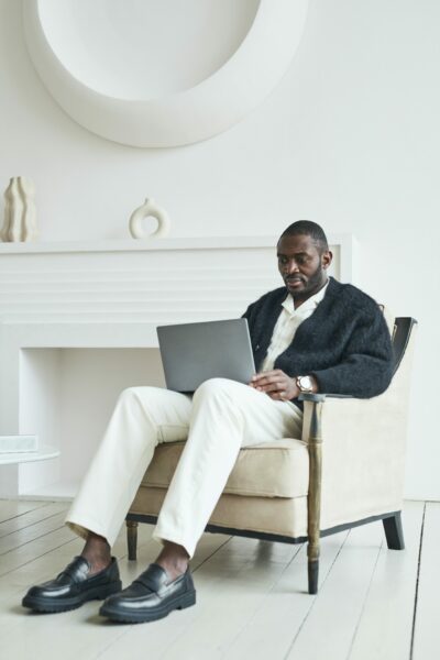 image of a man sitting in a chair working on a laptop