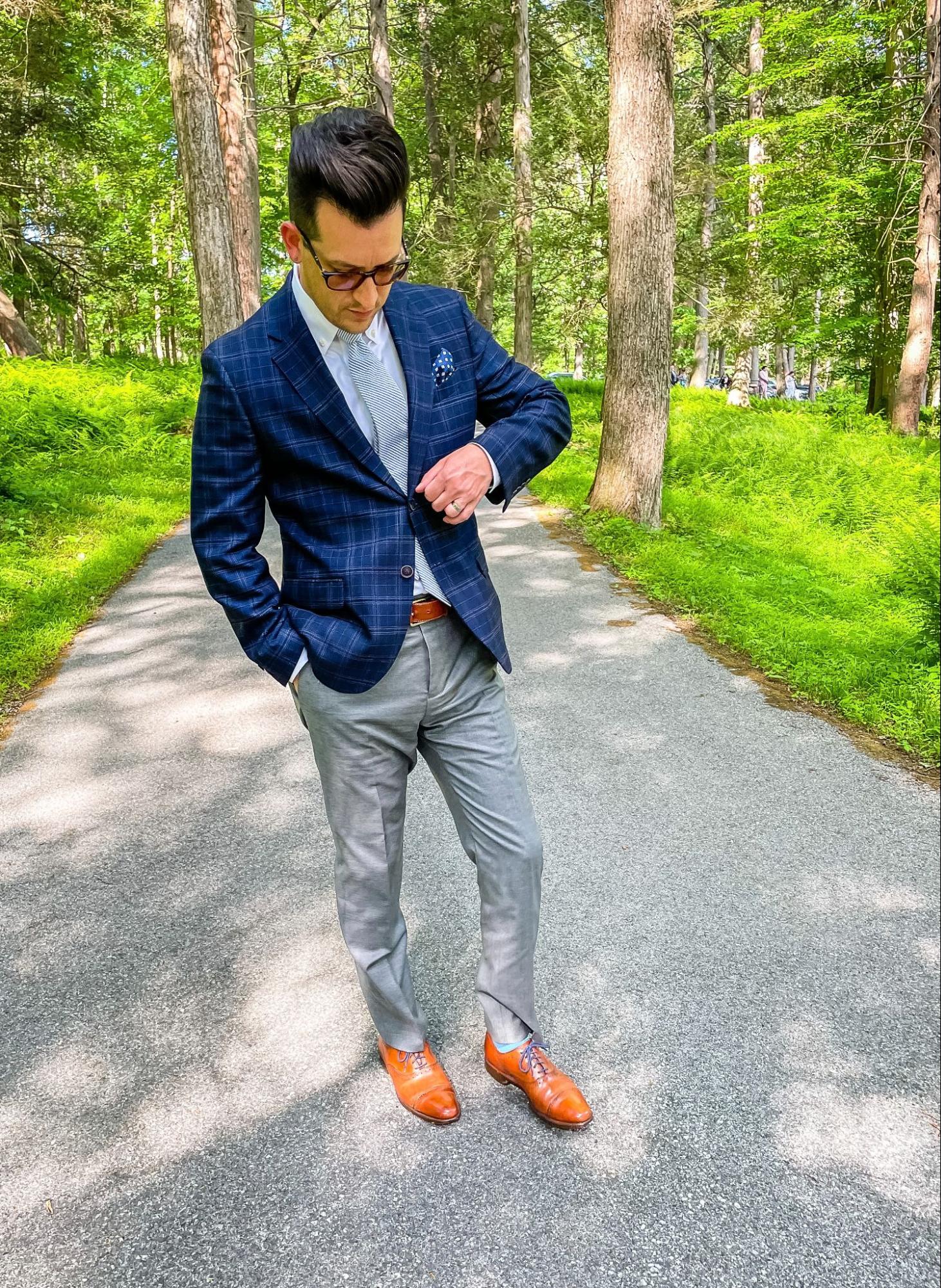 image of a man wearing a blue blazer gray pants brown shoes
