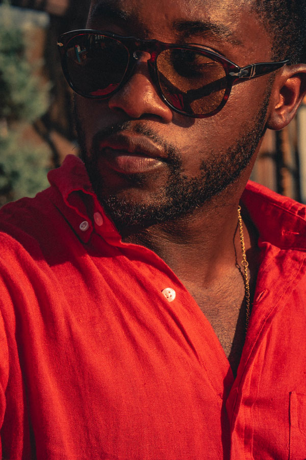 man wearing red linen shirt and sunglasses