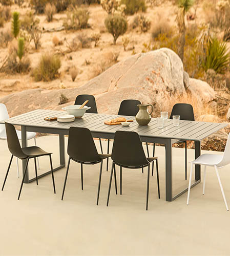 image of a wood and metal dining table with black and white plastic chairs
