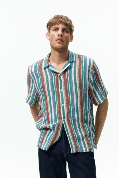 image of a man wearing a multi color spread collar striped short sleeve shirt