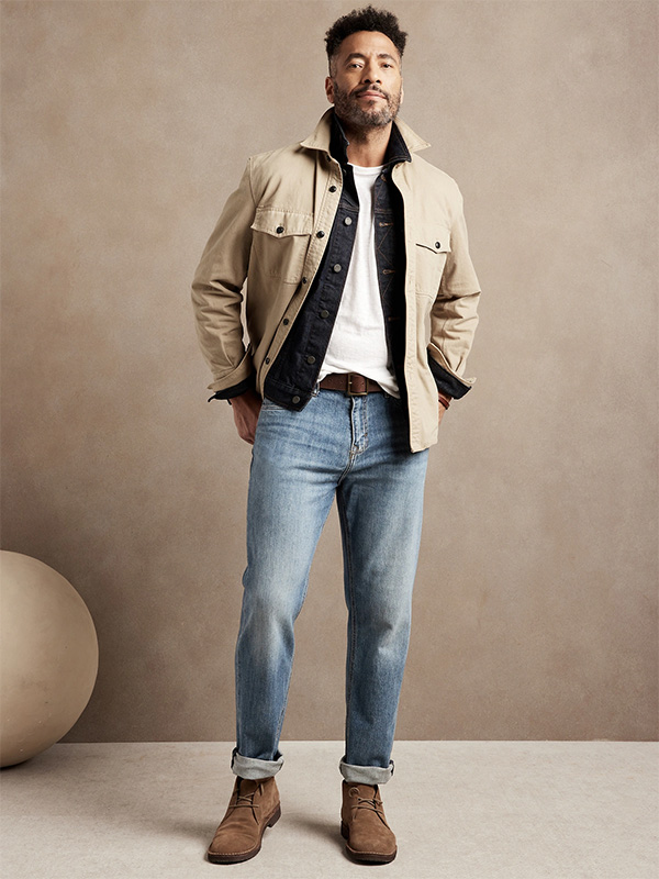 image of a man wearing a beige jacket and blue denim jeans