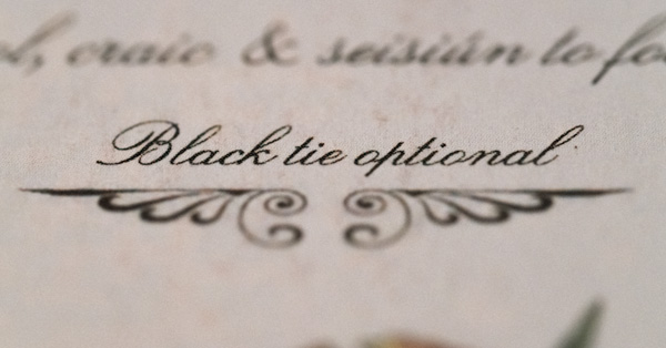 close up macro shot of invitation that says "Black Tie Optional"
