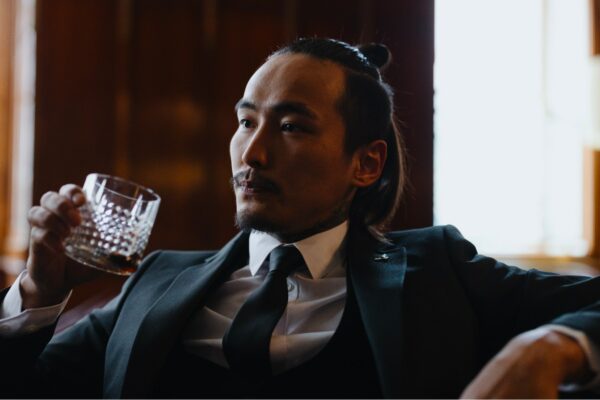 image of a man wearing a suit and tie and drinking a beverage