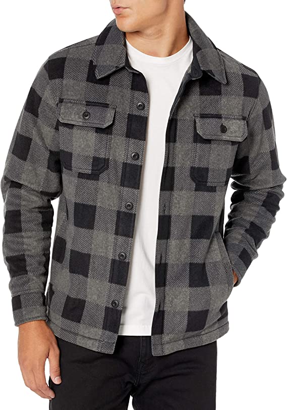 a man wearing a grey and black plaid shirt jacket over a white shirt