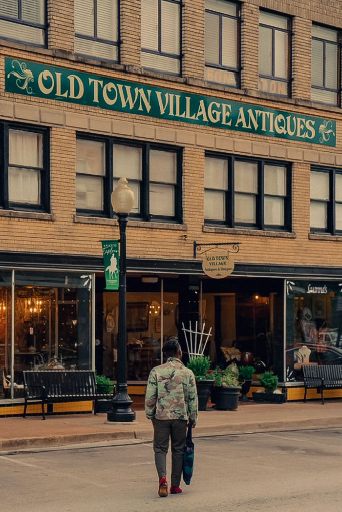 man walking towards a store that says Old Town Village Antiques
