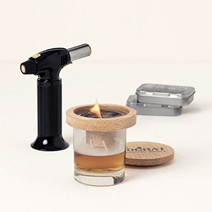 a cocktail smoker set with torch and glass topper