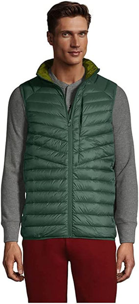 a person wearing a green puffer vest over a long sleeve grey shirt