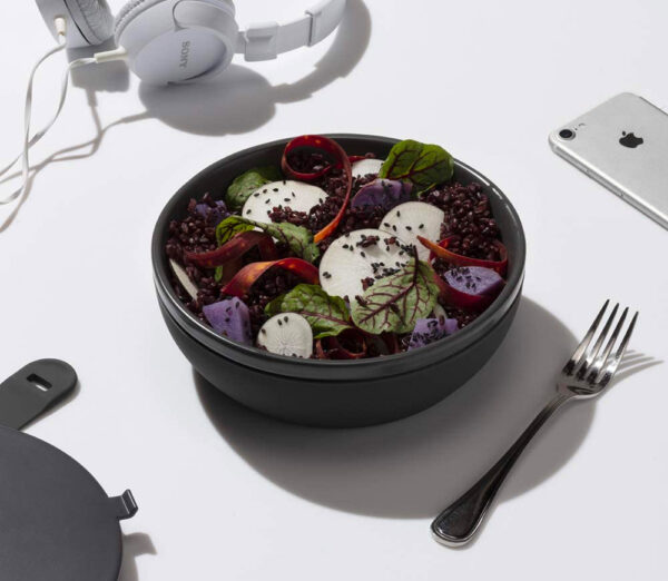 a black ceramic lunch bowl containing assorted vegetables