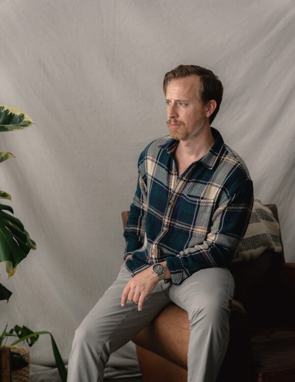 a man wearing a long sleeve button front plaid flannel shirt