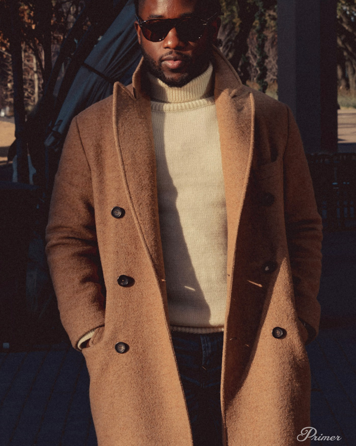 roll neck turtleneck sweater with camel color overcoat