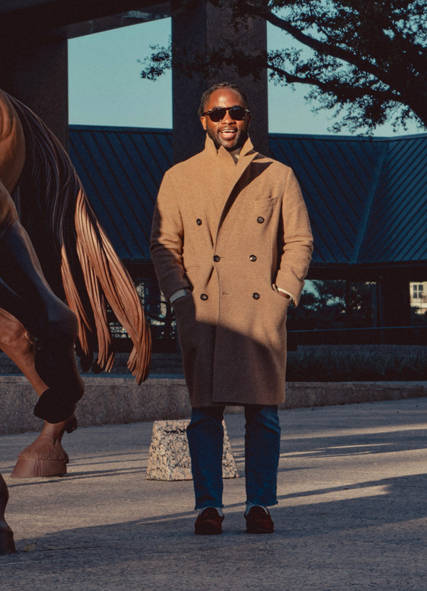 man wearing a camel overcoat with jeans and laofers