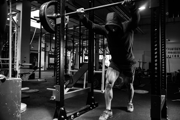 a man in a gym training with the squat machine