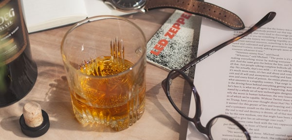 a glass of whiskey next to glasses