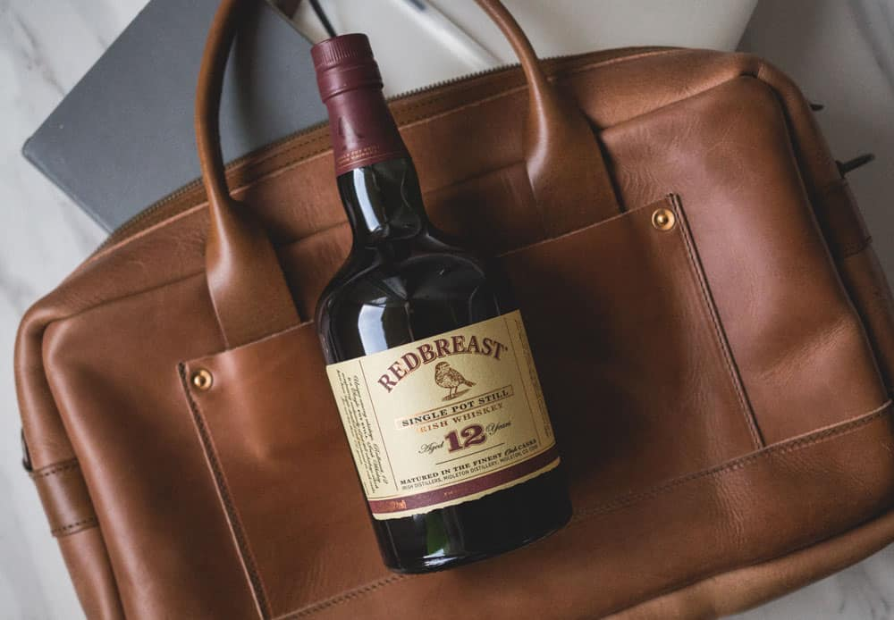 redbreast single pot still irish whiskey bottle on leather briefcase