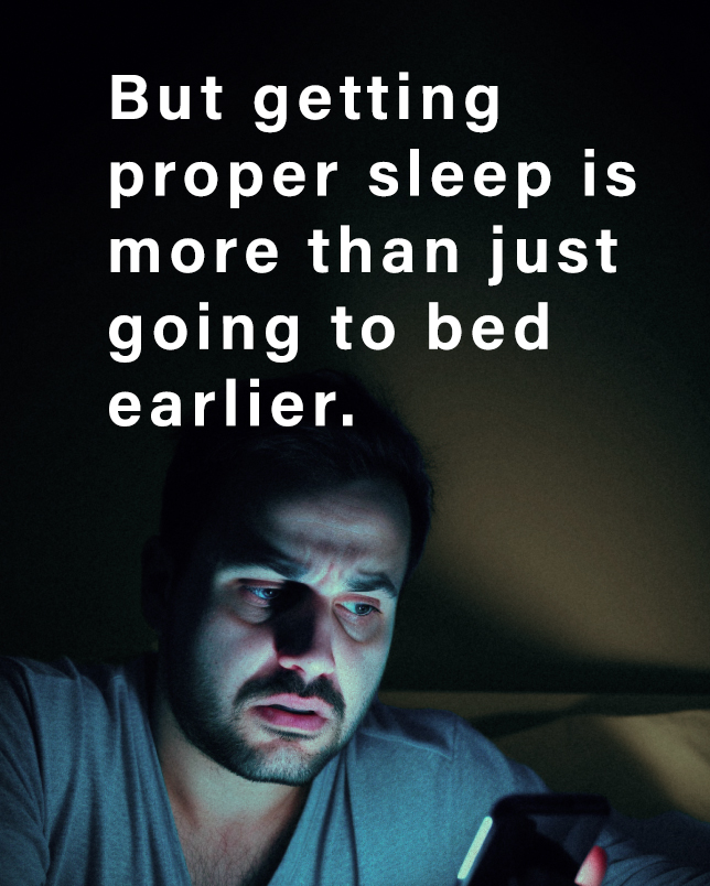 But getting proper sleep is more than just going to bed earlier. - man looking at phone in bed