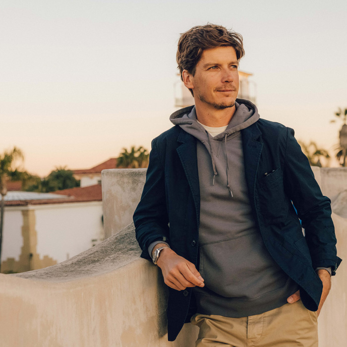 man wearing navy blazer with a grey hoodie