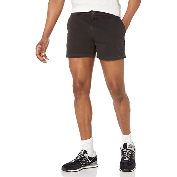 a man wearing flat front chino shorts and athletic shoes