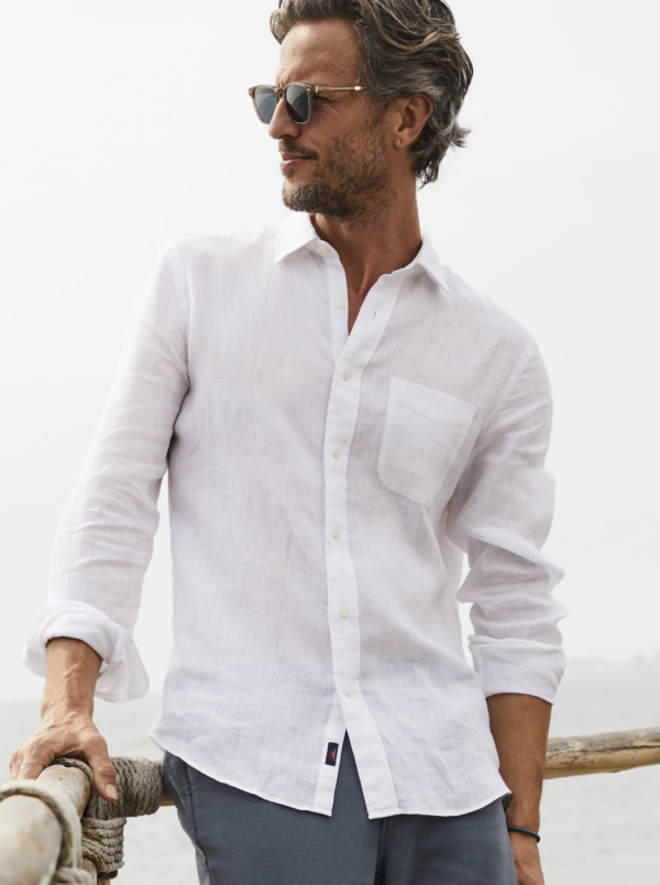 a man wearing a linen shirt and sunglasses