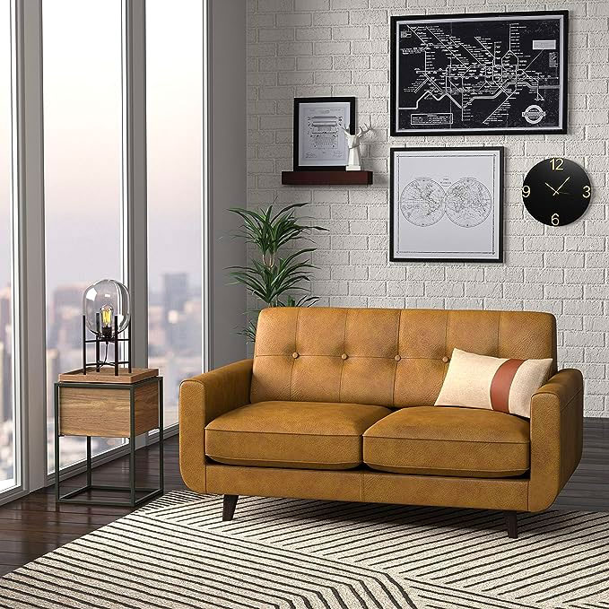 a brown leather loveseat in an apartment