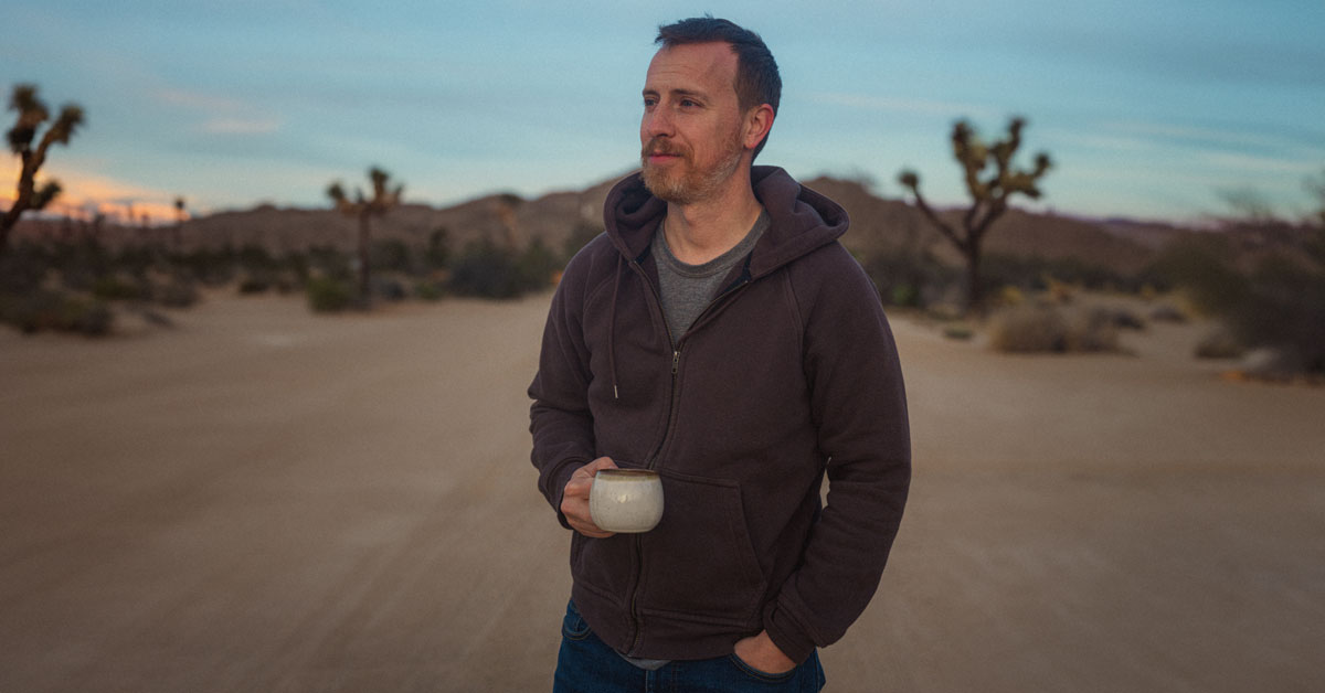 man wearing a flint & tinder hoodie in the desert