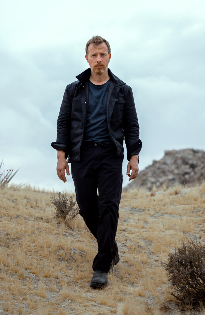 black outfit with black jacket, black jeans, and black boots with blue t-shirt