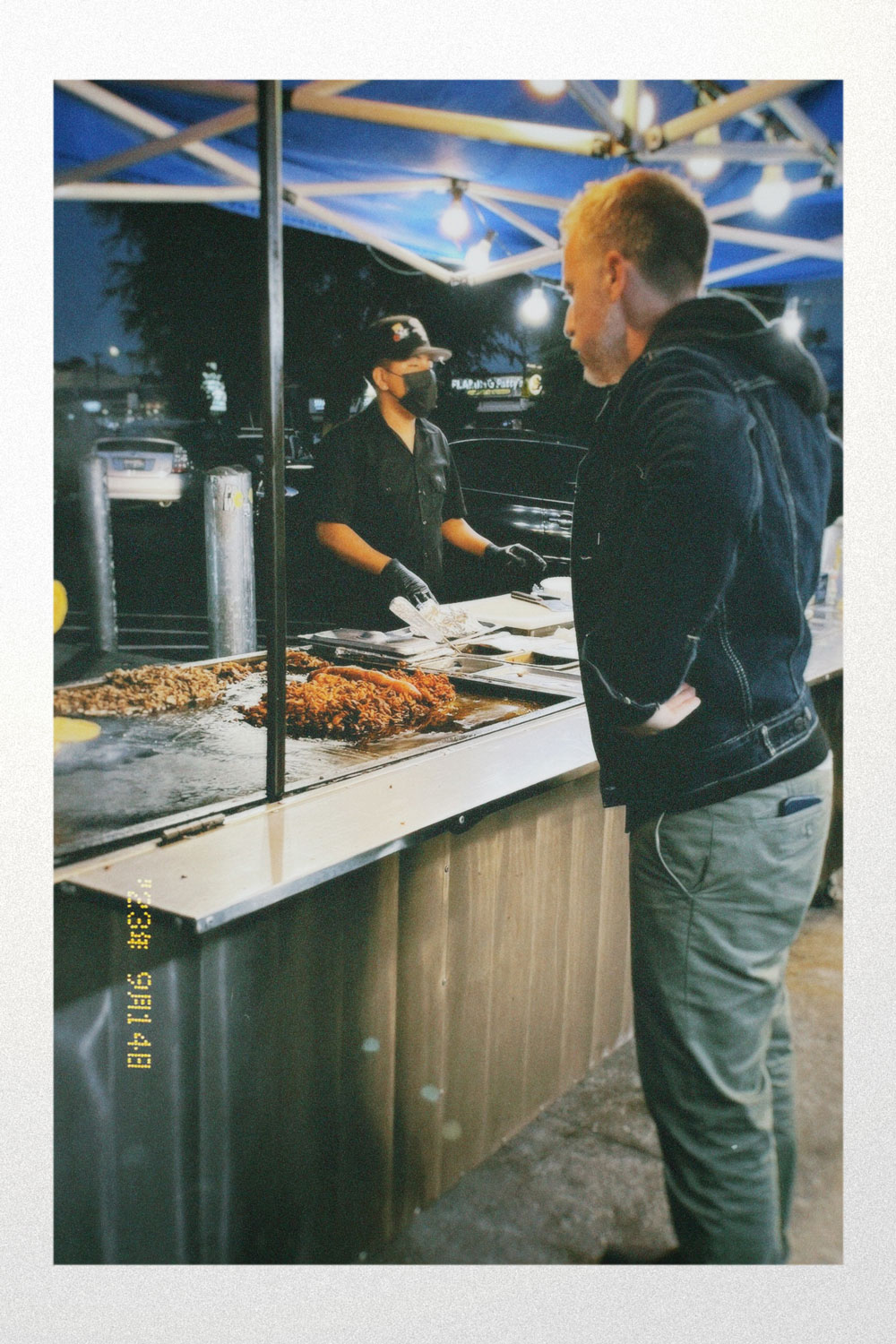 film photograph of man ordering from a taco stand