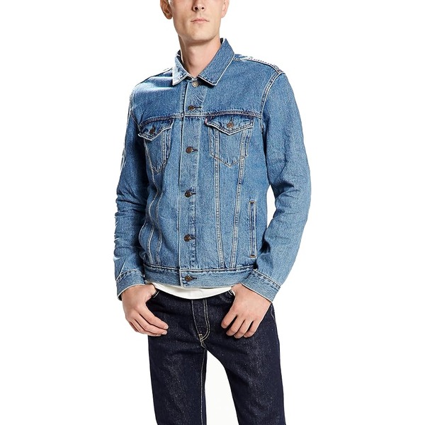 a man wearing a denim trucker style jacket with denim jeans