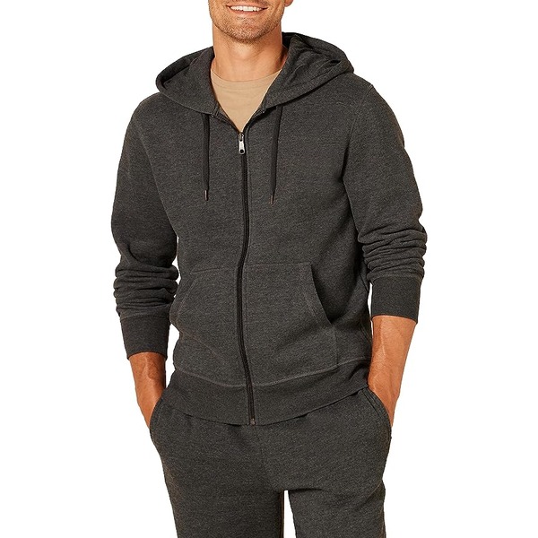 a man wearing a hooded zip front sweatshirt with casual pants