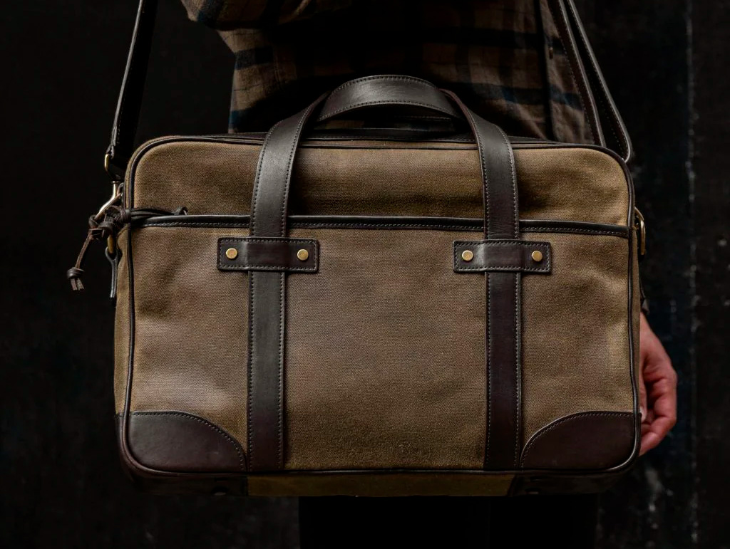 tan canvas briefcase with dark brown leather handles and accents