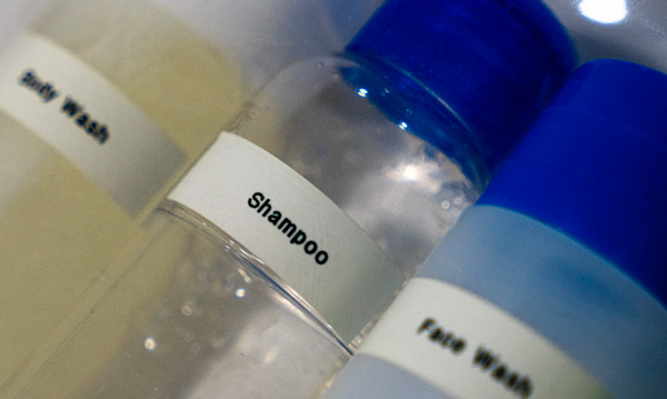 a label that reads 'shampoo' on a travel sized bottle
