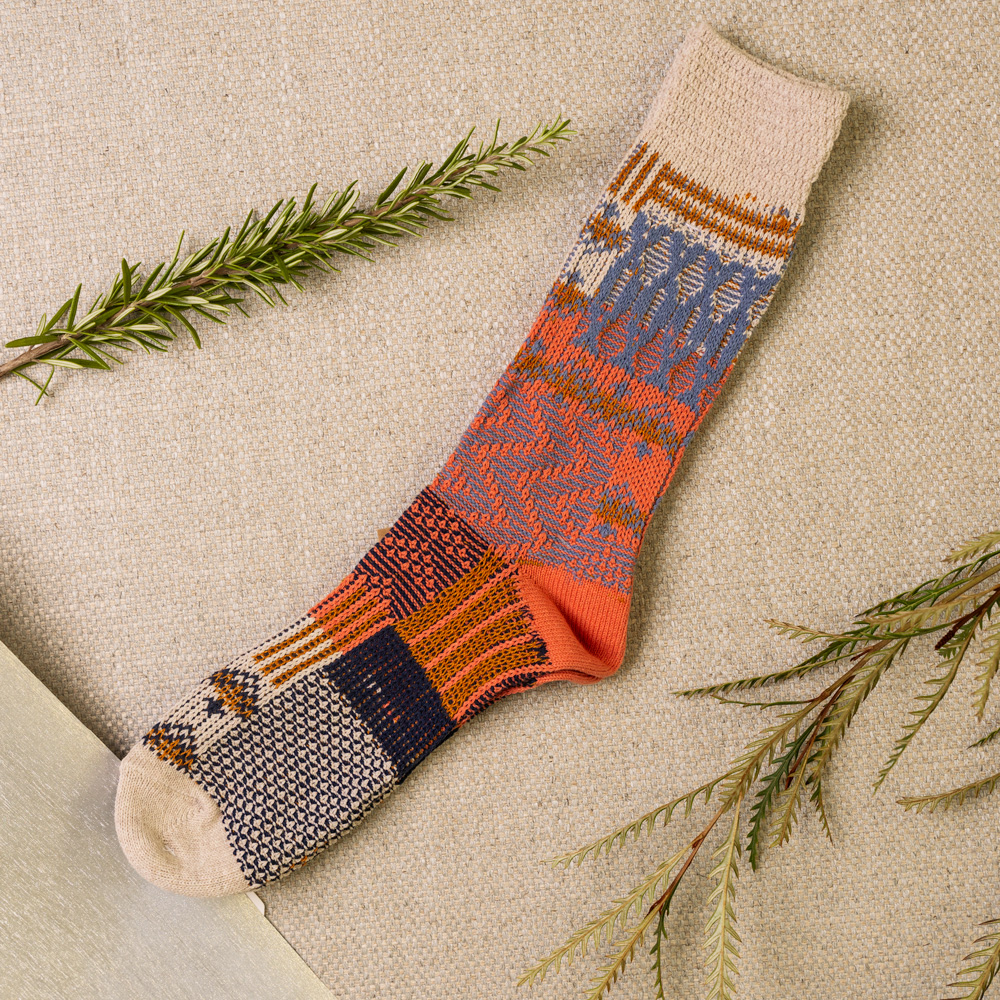 Primer Approved logo over a pair of colorful socks on a beige background