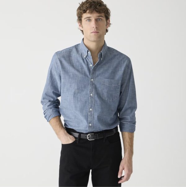 a man wearing a cotton chambray shirt and slim fit pants