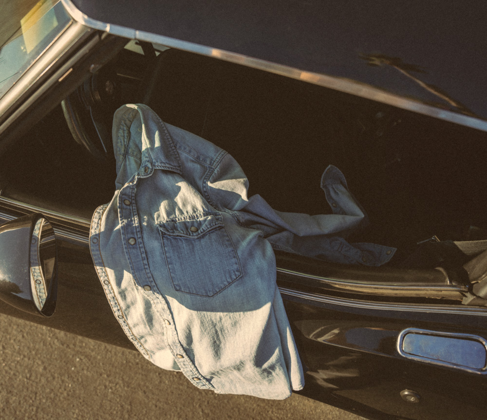 A denim shirt draped over a car door
