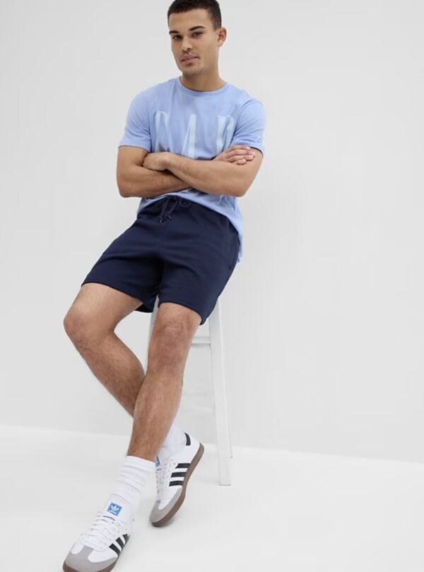 a man wearing french terry shorts with a shirt and casual shoes