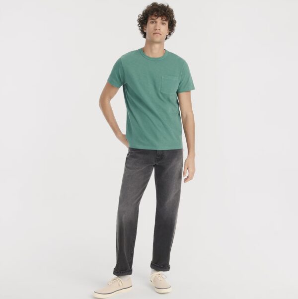 a man wearing straight fit grey jeans with a crew neck shirt and casual shoes
