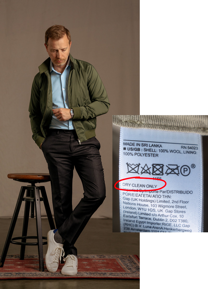 man wearing wool dress pants next to label with "dry clean only" circled