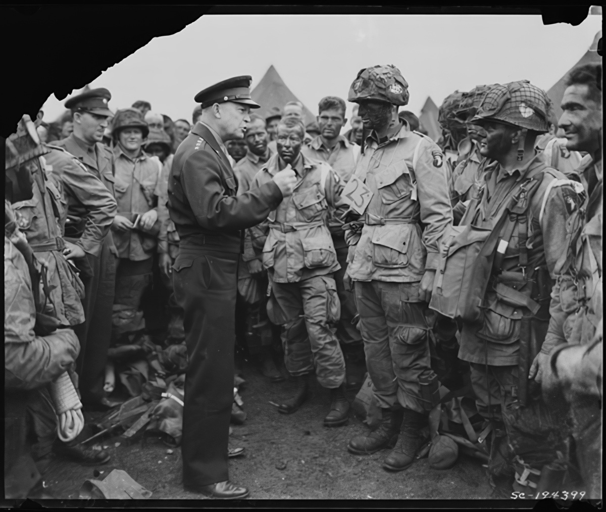 eisenhower addresses troops who are wearing filed jackets