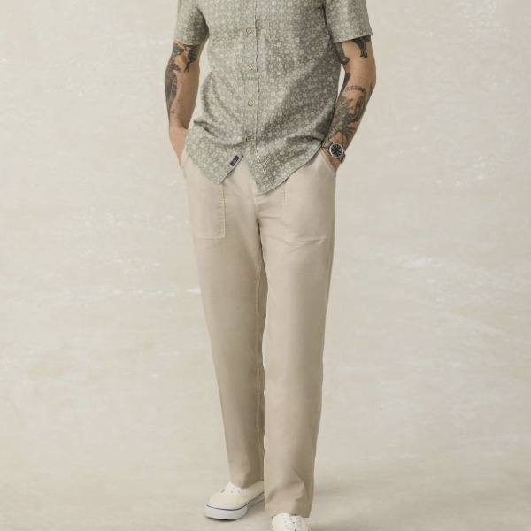 man wearing a drawstring waist utility style pant with a short sleeve button down shirt and casual shoes