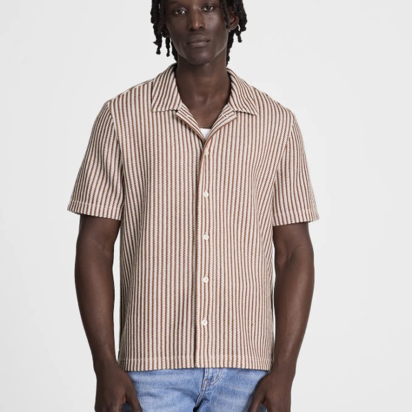man wearing a short sleeve button front textured striped shirt